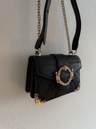 schwarze Umhängetasche mit goldenen Details