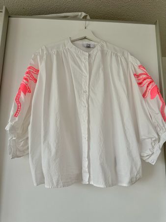 Weisse Damenbluse mit neon-pinker Applikatio