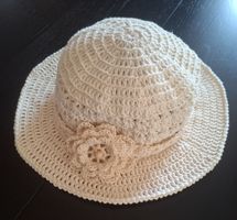 Chapeau crocheté fait main, beige, avec une fleur.