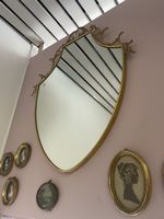 Miroir mural doré forme écusson style baroque ancien