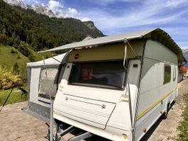 Wohnwagen mit Schutzdach und Zelt