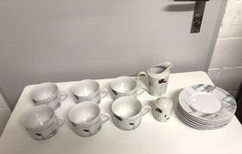 Tassen mit Untertassen, Milchkännchen und Streuer