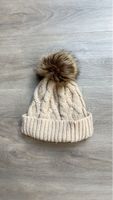 Bonnet en tricot beige avec pompon