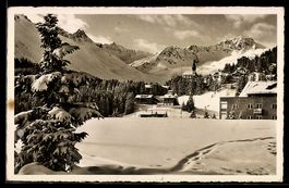 AK Arosa, Verschneite Ortsansicht mit Kirche, Tannen und Ber
