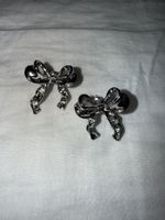 Silberfarbige Ohrstecker mit Schleife