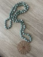Green beaded necklace with bronze pendant