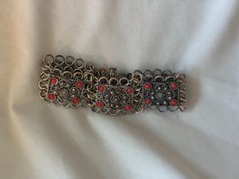 Armband mit Ornamenten und roten Steinen  Material unbekannt