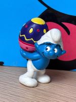 Schlumpf mit Osterei auf dem Rücken