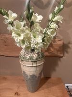 Eine Bodenvase mit einem kleinen Riss, mit künstlichen Blume