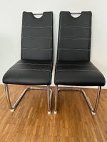 Deux chaises en similicuir noir avec pieds en métal