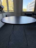 Runder Tisch mit schwarzer Platte und Metallgestell gebrauch