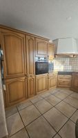 Holzküche mit Einbaugeräten und Vitrinenschrank