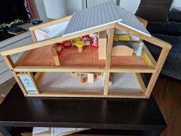 Holzpuppenhaus mit Möbeln und Bewohner