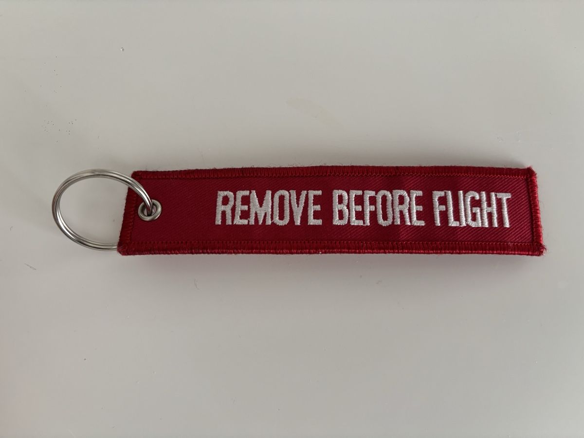 Portachiavi: Schlüsselanhänger "REMOVE BEFORE FLIGHT" rot/weiss – Nuovo e nell'imballaggio originale da Bülach venduto da Karuna 1