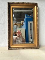 Spiegel mit goldenem Rahmen