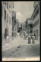 Andermatt, Strassenpartie mit Passantinn