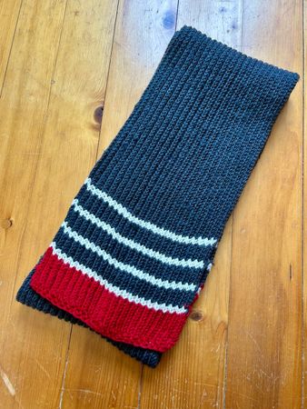 Kuscheliger selbstgestrickter grau-weiss-roter Schal