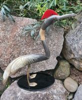 grosser Vogel aus Büffelhorn geschnitzt auf Glasplatte