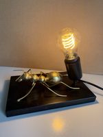 Tischlampe Ameise gold auf schwarzer Platte