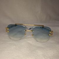 Blaue Sonnenbrille mit goldenen Bügeln