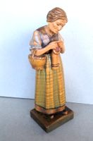 geschnitzte Holzfigur einer strickenden Frau, lasiert