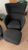 Dark gray armchair with a matching storage ottoman
