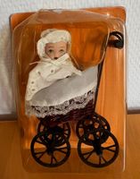 Miniatur-Puppenwagen mit kleiner Porzellanpuppe