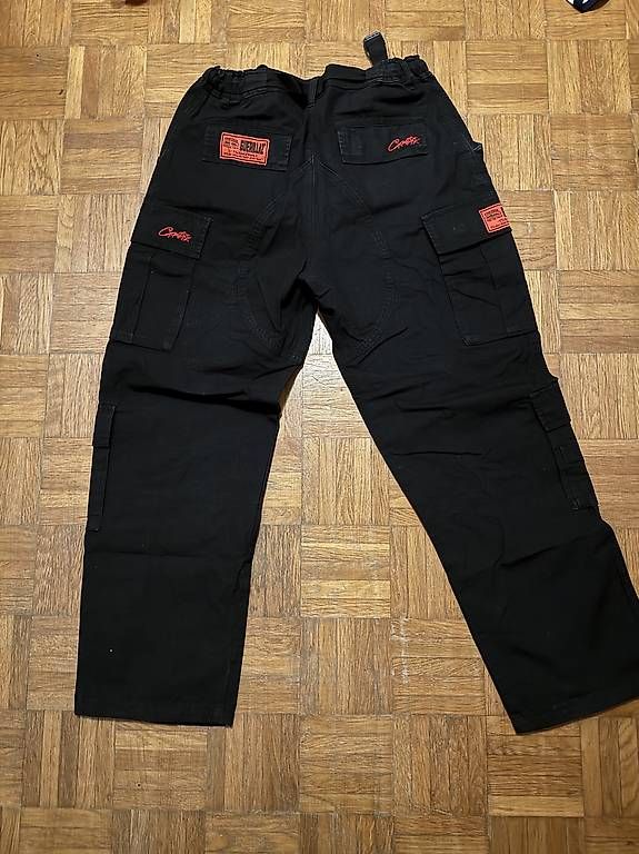 Pantalons: Cargo corteiz rouge/noir guerillaz – D'occasion à Morges par bir_9rsr 2