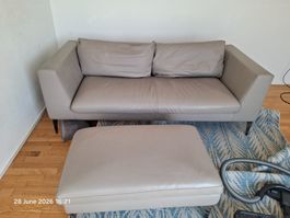 Hellgraues Kunstledersofa, 2-Sitzer mit Fußstütze, guter Zus