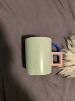 Keramik Tasse hellblau gesprenkelt mit buntem Henkel