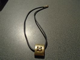 Kette schwarz, Anhänger Rechteck goldfarbig, weisser Stein