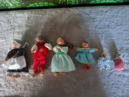 6 Püppchen aus Holz suchen neues Zuhause in einem Puppenhaus