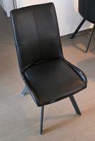 4 schwarze Stühle mit Abnutzungsspuren