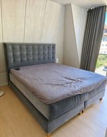 Graues Polster-Boxspringbett mit gesteppter Kopfstütze