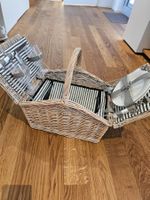 Picknickkorb geflochten mit Gläsern und Tellern