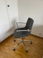 Grauer Bürodrehstuhl mit Chromgestell und Armlehnen