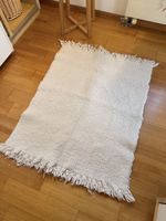 Cream textured rug with fringe