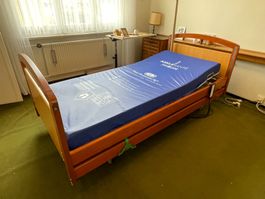 elektrisches Pflegebett mit Aufzug und Beistelltischchen