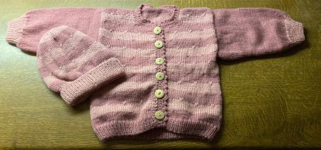 Selbstgestricktes farbiges Jäckchen mit Mütze für Kleinkind