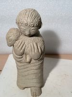 La petite statuette en pierre recomposée signe