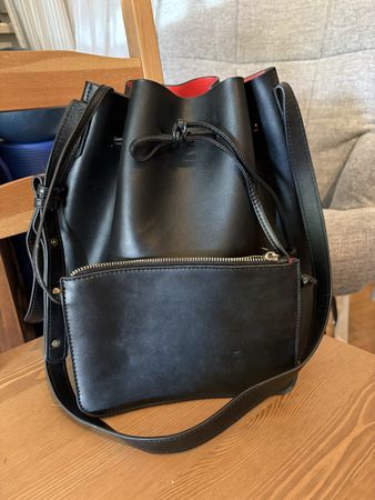 Schwarze Bucket Bag aus Kunstleder mit rotem Innenfutter