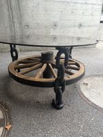 Rustikaler Couchtisch mit Rauchglas und altem Wagenrad