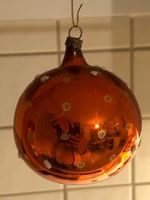 Antike, orangefarbene Weihnachtskugel mit weissen Punkten