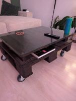 Massiver Couchtisch aus Palettenholz mit Glasplatte & Rollen