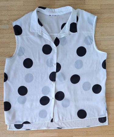 Chemisier blanc à pois noirs.