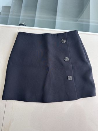 Black mini skirt by The Kooples with a wrap-style front and 