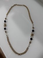 Goldkette mit schwarzen und weissen Akzenten.