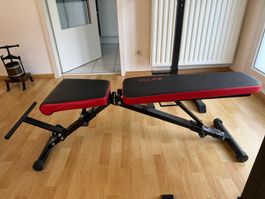 Banc de musculation incluant poids et barre.