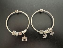 Zwei Armreifen von Pandora mit je 5 Charms