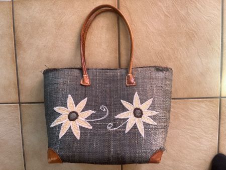 Sac en osier avec fleur, coins et poignées en cuir